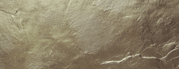 Metallic gold background with a textured, rough surface. The gold background adds a luxurious, elegant feel with its shimmering texture. Textured stone background vector. Gold background.