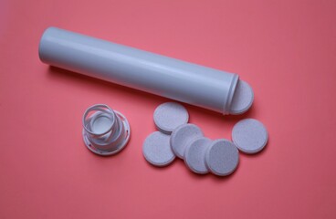 Effervescent Tablets with White Bottle on Pink Background Surface