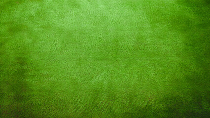 A close-up, top-down view of a simple casino mat in a rich, deep green color with a subtle, plush texture
