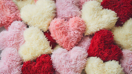 Valentine's Day, Fluffy heart-shaped cushions: A playful and comforting photo of a pile of fluffy heart-shaped cushions in pastel pink, white, and red, completely covering the frame
