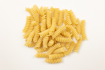 tas de pâtes crues fusilli, en gros plan, isolées sur un fond blanc