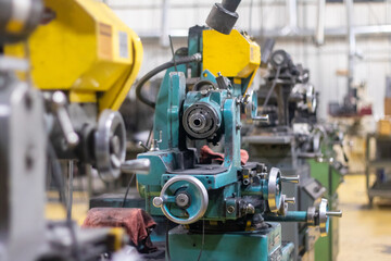 Fototapeta premium A big green and yellow industrial cutting machine in a warehouse.