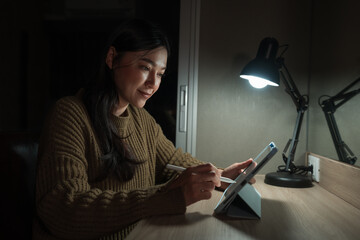 woman working with digital tablet at night