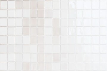 Fototapeta premium A textured surface composed of small white tiles, featuring subtle variations in shade and pattern, creating a minimalist aesthetic.