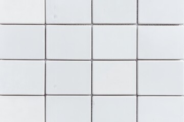 A clean, minimalistic arrangement of square tiles in a grid pattern, showcasing a uniform pale color and simple design.