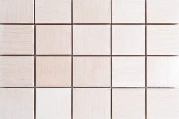 A grid of light-colored tiles arranged in a neat pattern, showcasing subtle textures and a clean aesthetic.