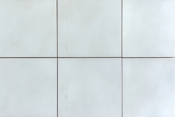 A clean, modern surface of light-colored tiles arranged in a grid pattern, accentuated by thin grout lines.