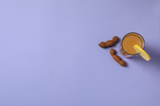 Tamarind juice in a glass with an orange