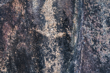 The surface of the stone is cracked. Dark background. The texture of the stone. Stone backgrounds