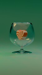 A transparent glass holds one red and white striped heart-shaped candy inside on a green background