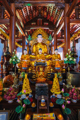 There are many Buddhist golden Buddha statues inside a temple in a pagoda in Nha Trang, Asia