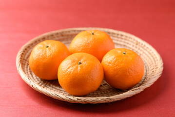 Mandarin tangerine orange fruit in basket on red background, Lucky food in Lunar New Year or Chinese New Year