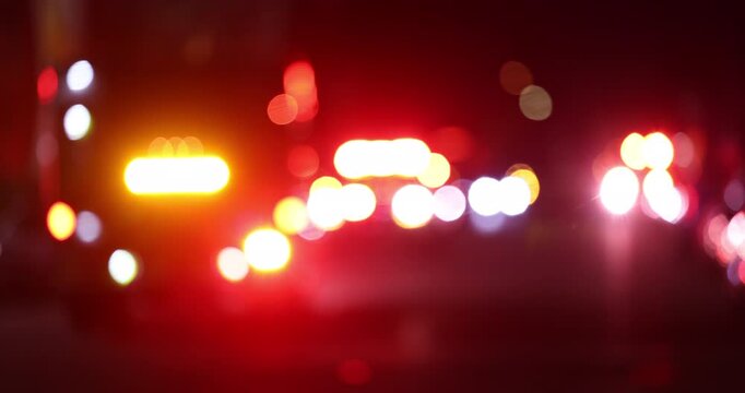 Abstracted blurred bokeh view of a fire engine responding to the scene of an emergency at night.