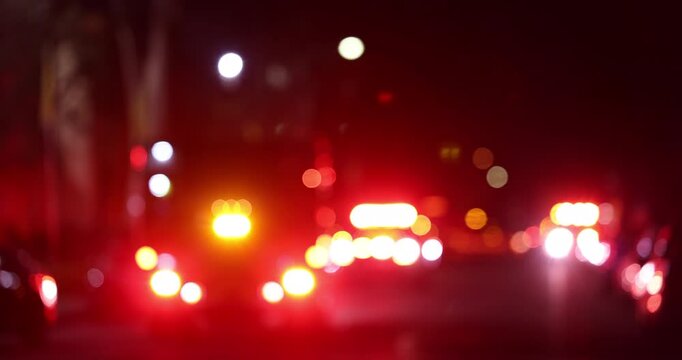 Abstracted blurred bokeh view of a fire engine responding to the scene of an emergency at night.
