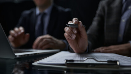 Close-up of a hand using a writing pen with a paperwork questionnaire or survey,