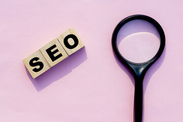 SEO search Engine optimization print on wooden cube with magnifying glass, Marketing ranking...