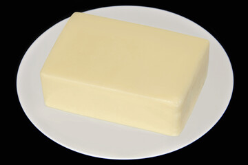 MOZZARELLA CHEESE BAR ON PLATE ISOLATED ON BLACK BACKGROUND