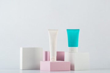 Plastic white tube for cream or lotion. Skin care or sunscreen cosmetic with stylish props on white background.