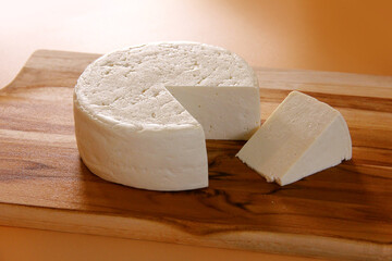 MINAS FRESCAL CHEESE ON WOODEN BOARD WITH CUT PIECE ON ISOLATED BACKGROUND - TRADITIONAL CHEESE FROM MINAS GERAIS