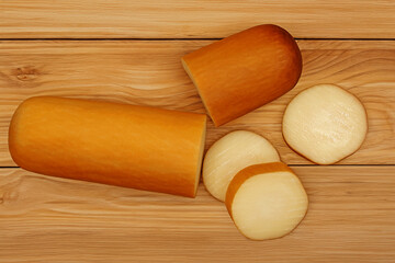 PROVOLONE VIEW FROM TOP WITH CUT CHEESE PIECES ON WOODEN TABLE ISOLATED