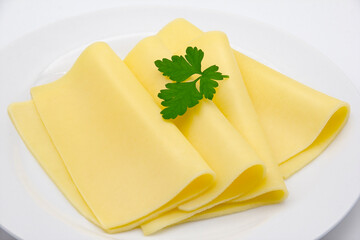 CLOSE UP SLICED CHEESE WITH PARSLEY DETAIL ON DISH ISOLATED WHITE BACKGROUND
