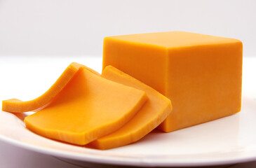 YELLOW CHEESE BAR (PLATE) SNACK SLICED ON A DISH ISOLATED ON A WHITE BACKGROUND