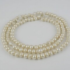 Obraz premium Creamy Pearl Necklace: Three strands of lustrous cream-colored pearls create an elegant and timeless necklace, perfect for adding a touch of sophistication to any outfit.