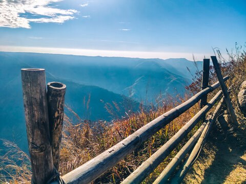 Mountain Trail with Wooden Fence Serene Viewpoint Overlooking Misty Hills at Sunrise