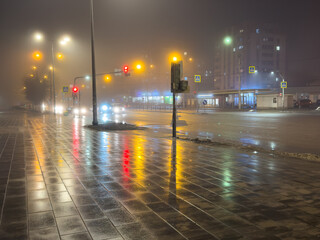 A rainy night with a street light shining on the wet pavement