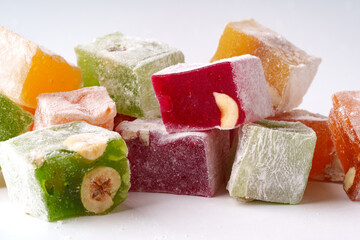 Colorful assortment of traditional Turkish delight with nuts displayed on a white background
