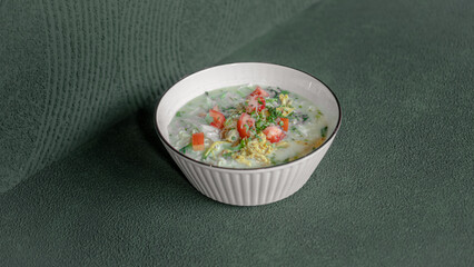 Warm and Flavorful Chicken Porridge Topped with Fresh Tomato Slices, Served in a Bowl for a Comforting and Satisfying Meal.