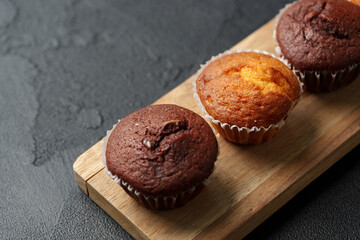 Enjoying freshly baked chocolate and vanilla muffins on a wooden board in a cozy kitchen setting