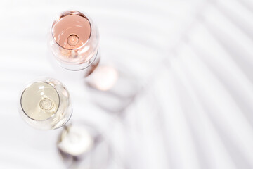 Two wine glasses filled with rose and white wine