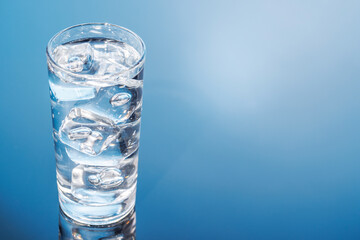 A clear glass filled with chilled water and ice cubes, creating a refreshing and cool drink