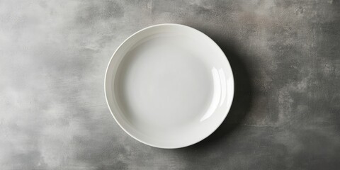 Elegant white ceramic plate with elevated edges centered on a soft grey textured background ideal for design and mockup purposes