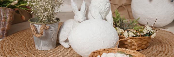 Interior floral Easter composition. Figurines of Easter bunnies and a large eggshell.