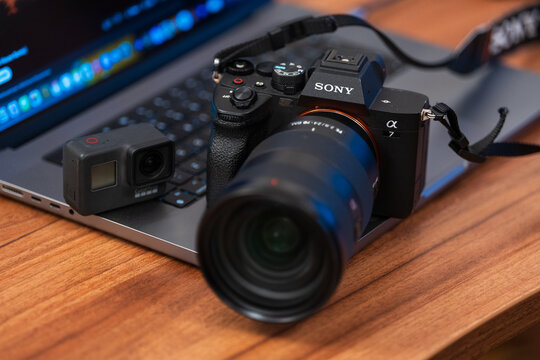 Bucharest, Romania 22 January 2025.Sony Alpha 7 IV Full-frame hybrid camera and GoPro Hero 7 black action camera, on a gray laptop background .