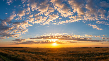 Obraz premium A backdrop of blue sky adorned with clouds, showcasing a stunning landscape featuring clouds illuminated by an orange sun