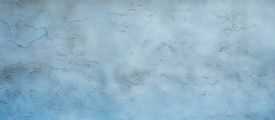 Obraz premium Light blue textured stucco wall with a rough plaster surface and soft gradients, featuring a subtle copy space for design elements.