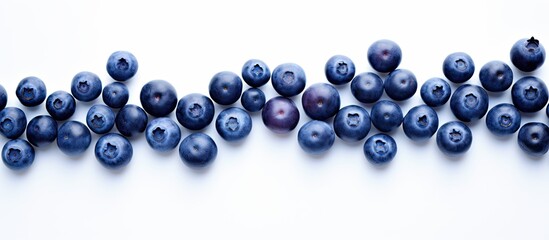 Fototapeta premium Fresh Blueberries on a White Background arranged in a line with various shades of deep purple and blue showcasing natural texture and freshness.