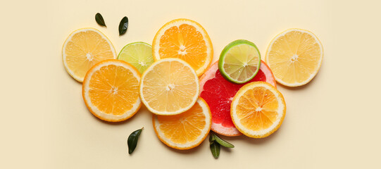 Many different cut citrus fruits on beige background, top view