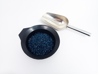 Dark blue masterbatch, polymer granules carrying pigment inside stainless steel scope, isolated on...
