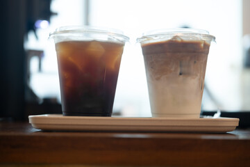 Close up of iced coffee latte and ice black coffee in takeaway plastic glass with ice. Cold beverage product