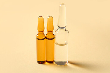 Glass medical ampules on light yellow background
