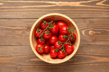 Bowl with fresh cherry tomatoes on wooden background