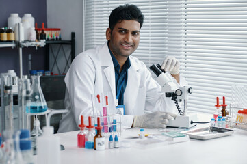 Fototapeta premium Scientist conducting research in laboratory environment, surrounded by scientific equipment and various chemical samples on lab bench