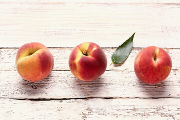 Sweet peaches on white wooden background