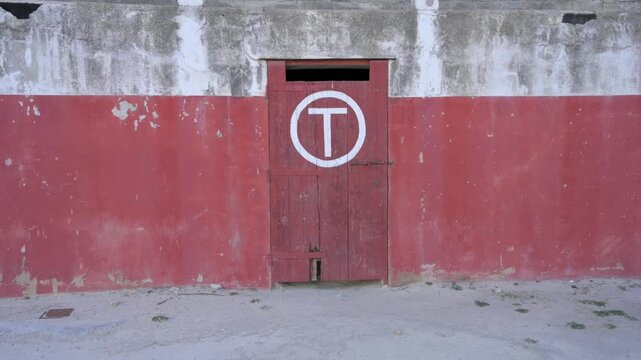 Side view of a red toril gate in an abandoned bullring in Rubielos de Mora
