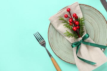Beautiful table setting with Christmas tree branch and rowan on turquoise background