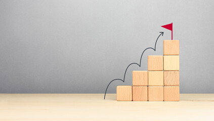 Wooden block stacking as step stair with arrow up and flag target icon. Ladder of success in...